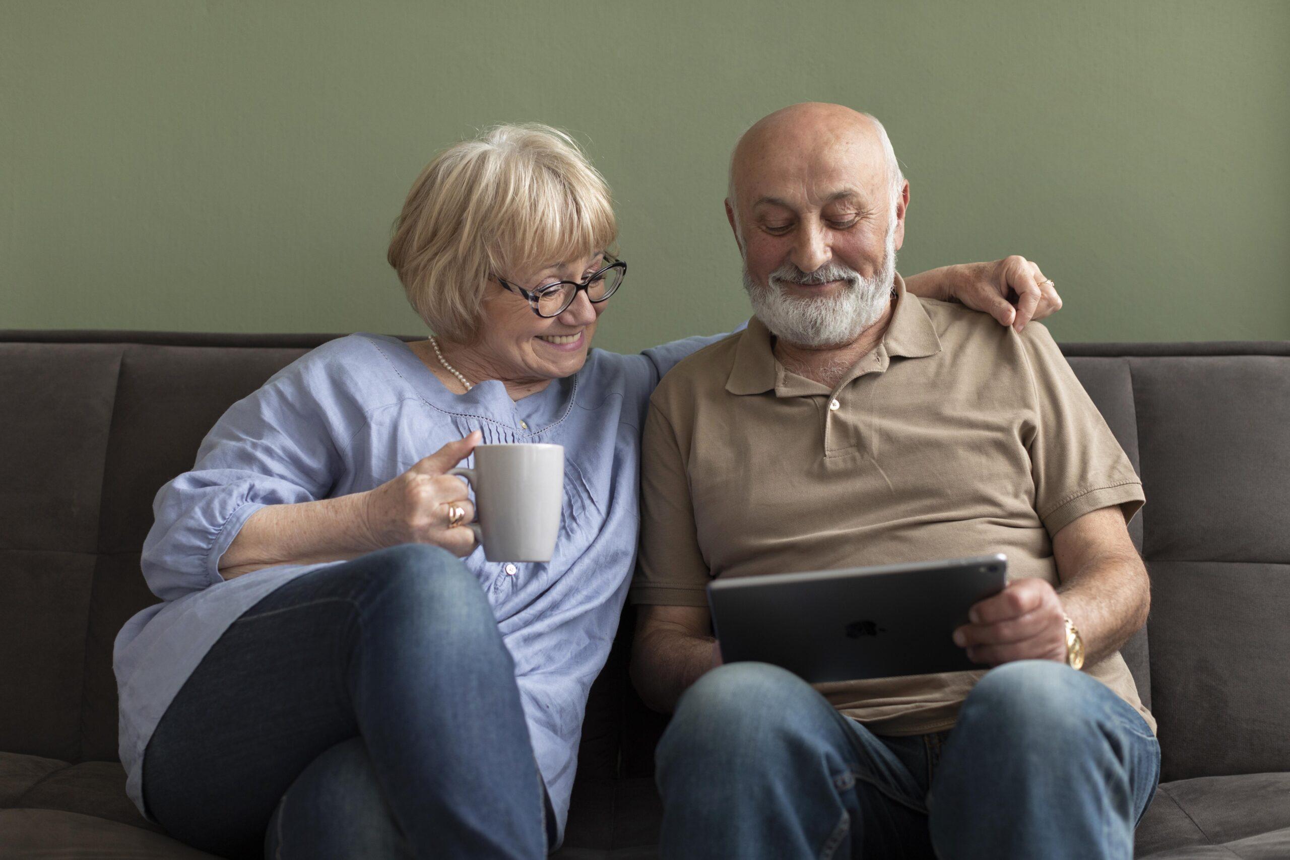 senior couple looking tablet medium shot scaled