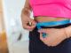 weight loss concept portrait millennial african american lady top bra leggings measuring her waist using blue tape free copy space black woman checking body parameters